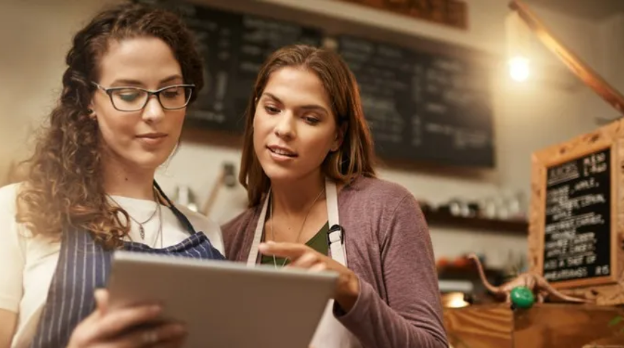 Women holding tablet in store on Small Business Saturday.