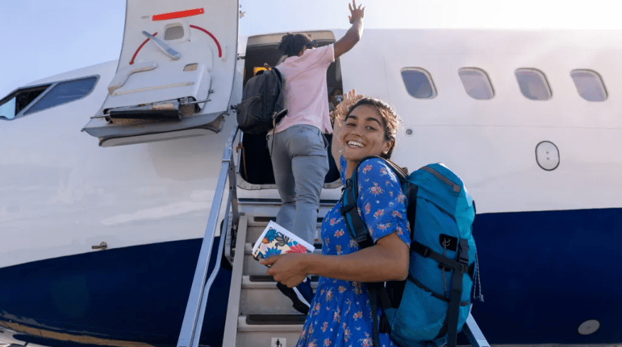 Girl boarding a plane on the runway at the airport.