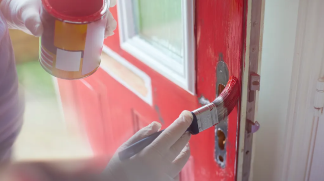 Homeowner gives his front door a new coat of paint.