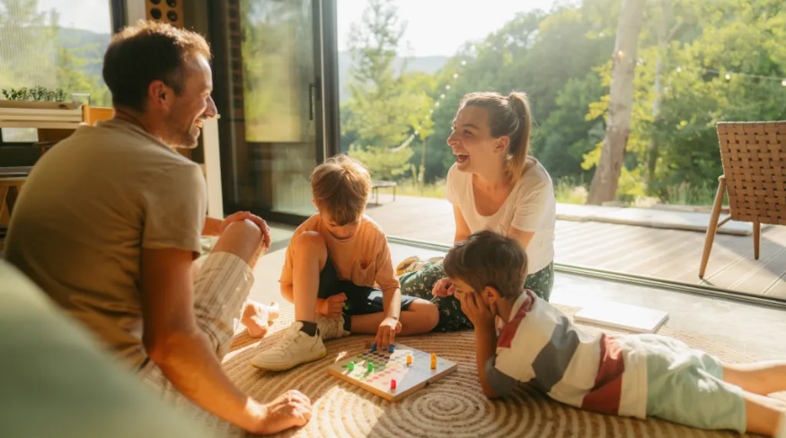 Young family playing board games together on the floor.
