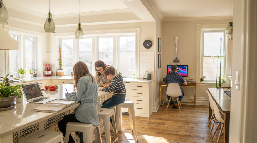 Family working in two separate spaces in open concept home.