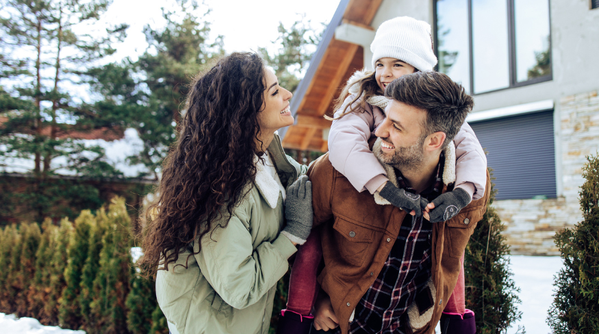 Happy family playing outside in the snow.